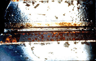 A lubricant contaminated with water produced corrosion on this helical gear. A lubricant contaminated with water produced corrosion on this helical gear.
