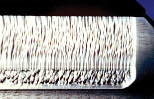 A lubricant contaminated by sand resulted in abrasion on this spur pinion. A lubricant contaminated by sand resulted in abrasion on this spur pinion.
